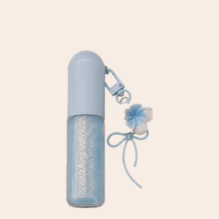 A pale blue glitter body shimmer on a clip, with a blue frangipani charm and a ribbon bow